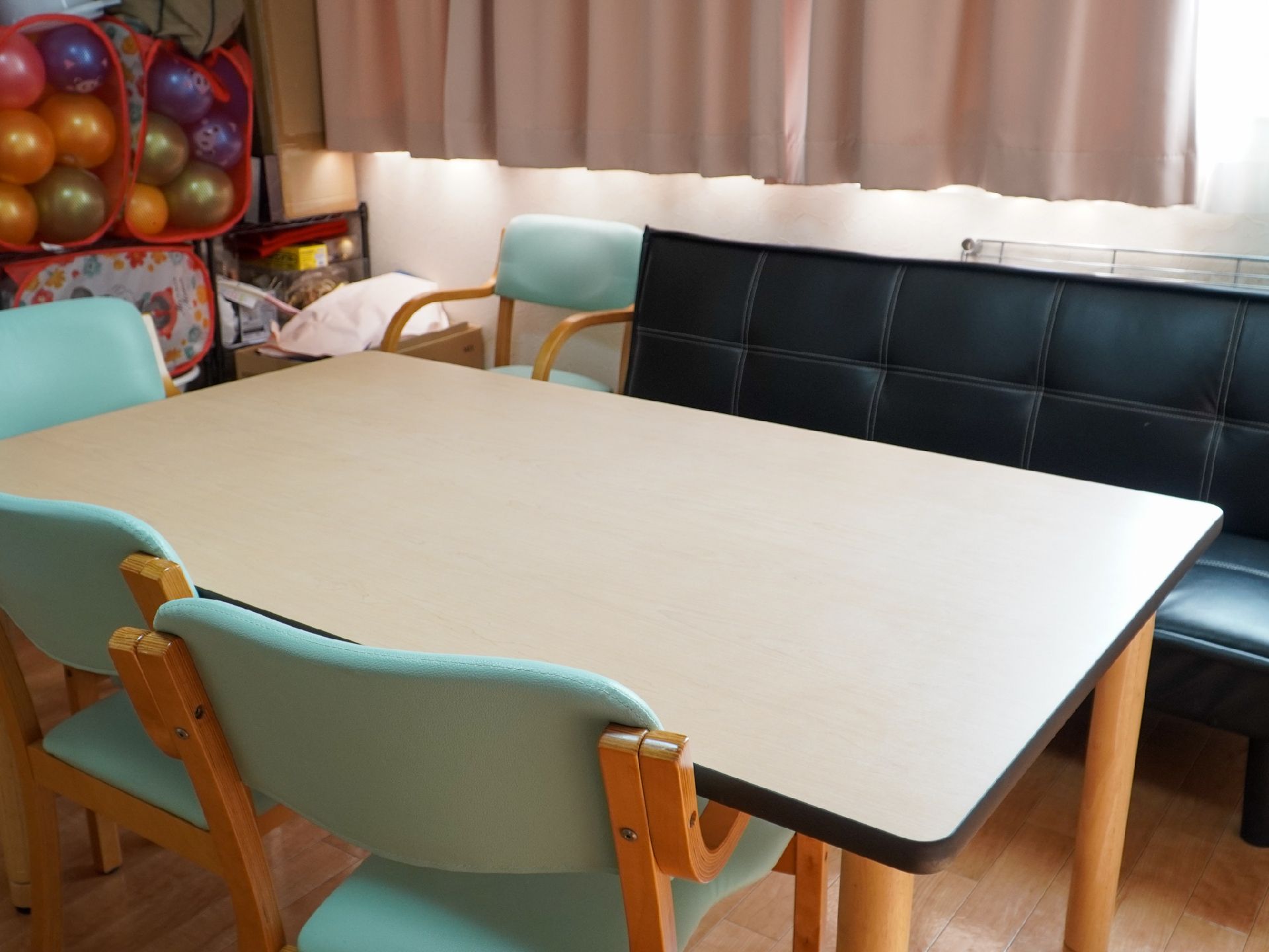 木製の机の周りに椅子が配置された部屋