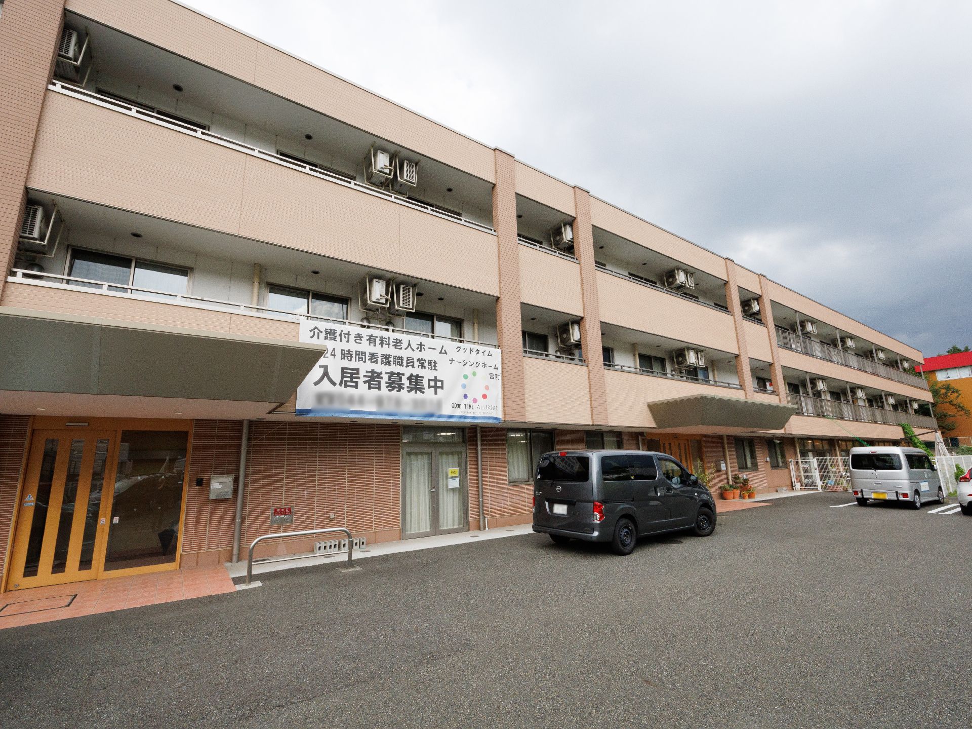 駐車場の出入り口から見た、斜め前から見た施設全体の外観