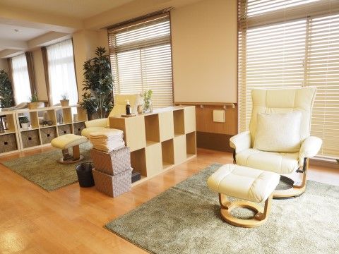 カラーボックスで浅く仕切られた場所に、足置き付きのチェアが置かれたリクライニングスペース