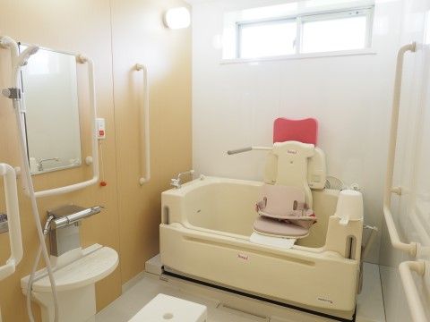 リフトの座部に腰掛けて、リフトを昇降させて入浴するタイプの入浴装置である。各所に手すりが設置され、非常ボタンもある。
