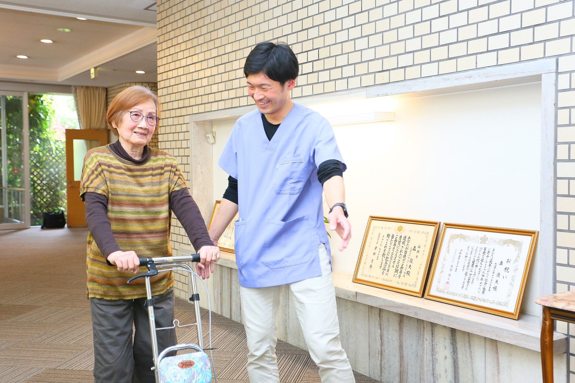 銀色の看板がたてられており、自動ドアがある施設入り口