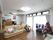 床がフローリングの広い部屋に白いソファが用意され、入居者様が座っている。周りにはテレビやクリスマスツリーなどが置かれている。