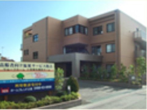 建物の前には看板が設置されている。エントランスは広々としていてポーチには屋根があるので送迎の際なども便利である。