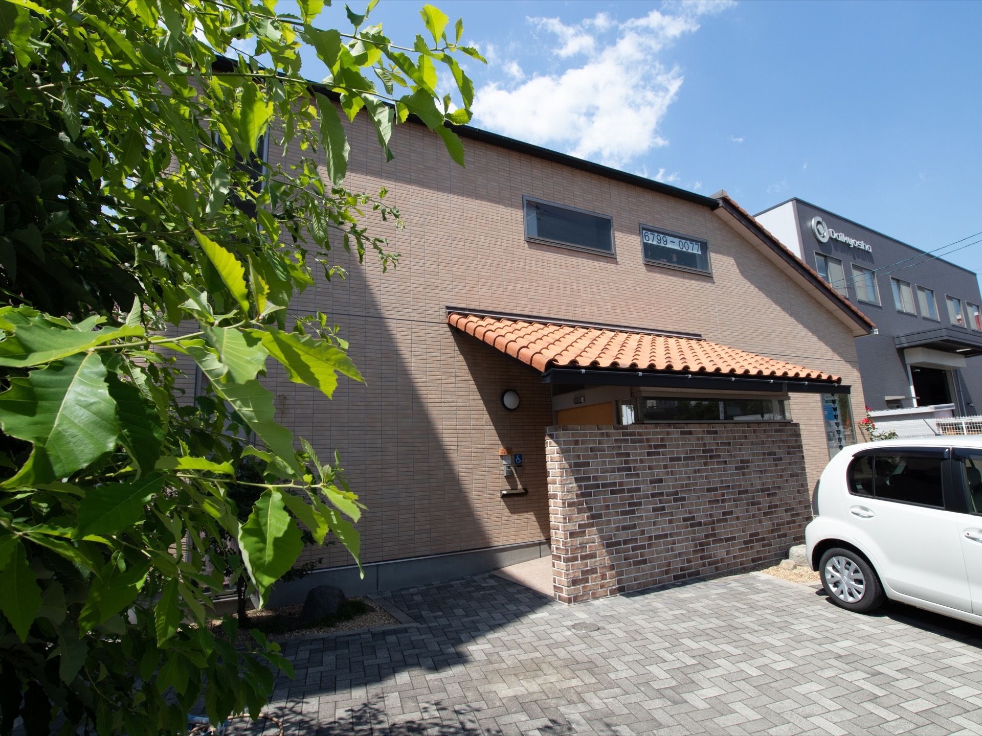建物は2階建てで、玄関にれんが屋根のひさしと目隠しの塀が作られている。建物前の足元には砂利が敷かれ、駐車スペ―スが設けられている。