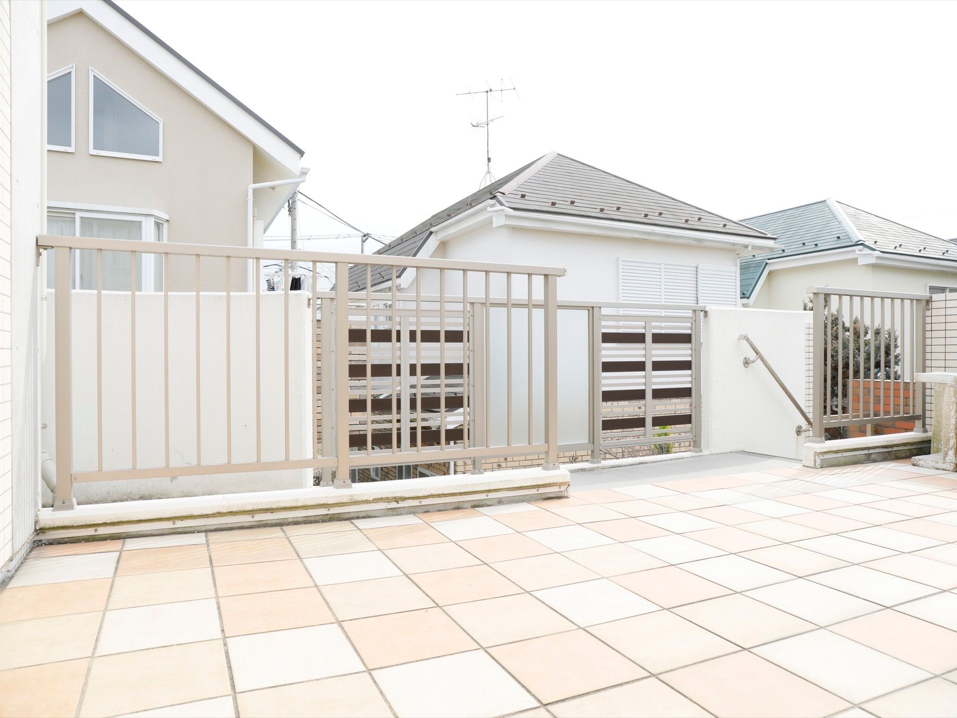 周辺は高い建物がなく、民家になっている。階段には手すりがついている。足元は、淡い色のタイルが綺麗に敷かれている。