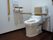 居室に備わっているトイレにはナースコールが設置され、跳ね上げ式の手すりや背面クッションが付いている。