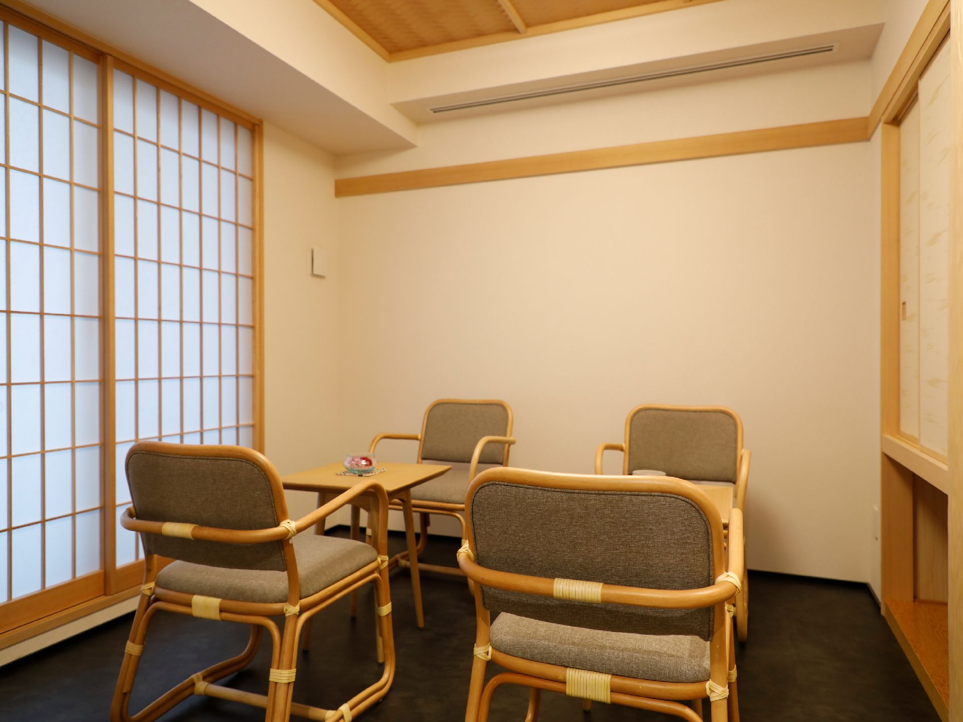 障子や襖の押入れなど、和風のしつらえの小さな部屋である。小テーブルが二つあり、それぞれに椅子が2脚ずつ向かい合って置いてある。