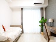 居室には、介護用電動ベッドやエアコン、カーテンが完備されている。壁際には、デスクが設置されており、椅子や観葉植物が置かれている。
