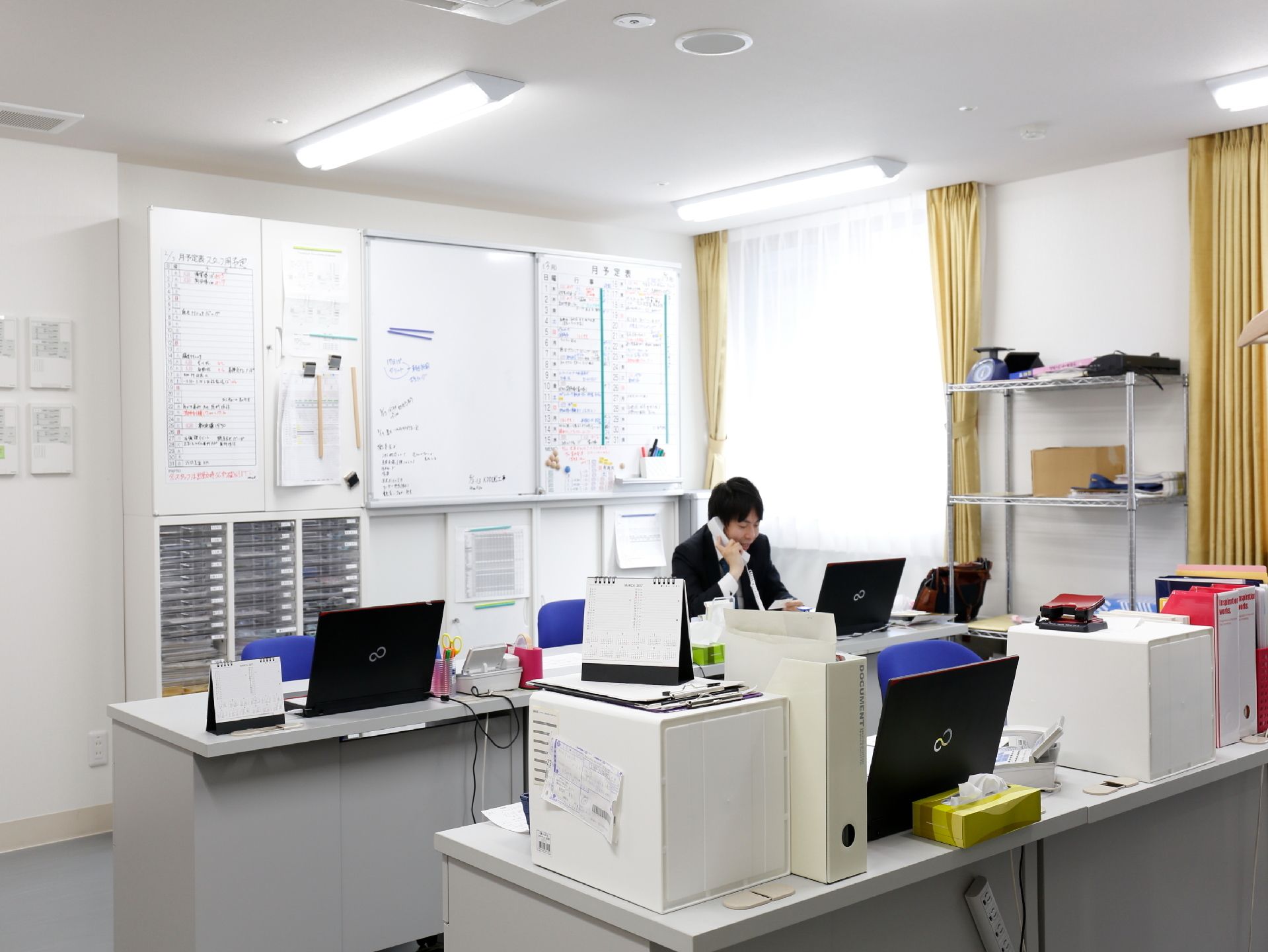 事務室には机と椅子が二列に並んでいる。机の上にはパソコンが用意されているので、パソコンでの事務作業を行える。