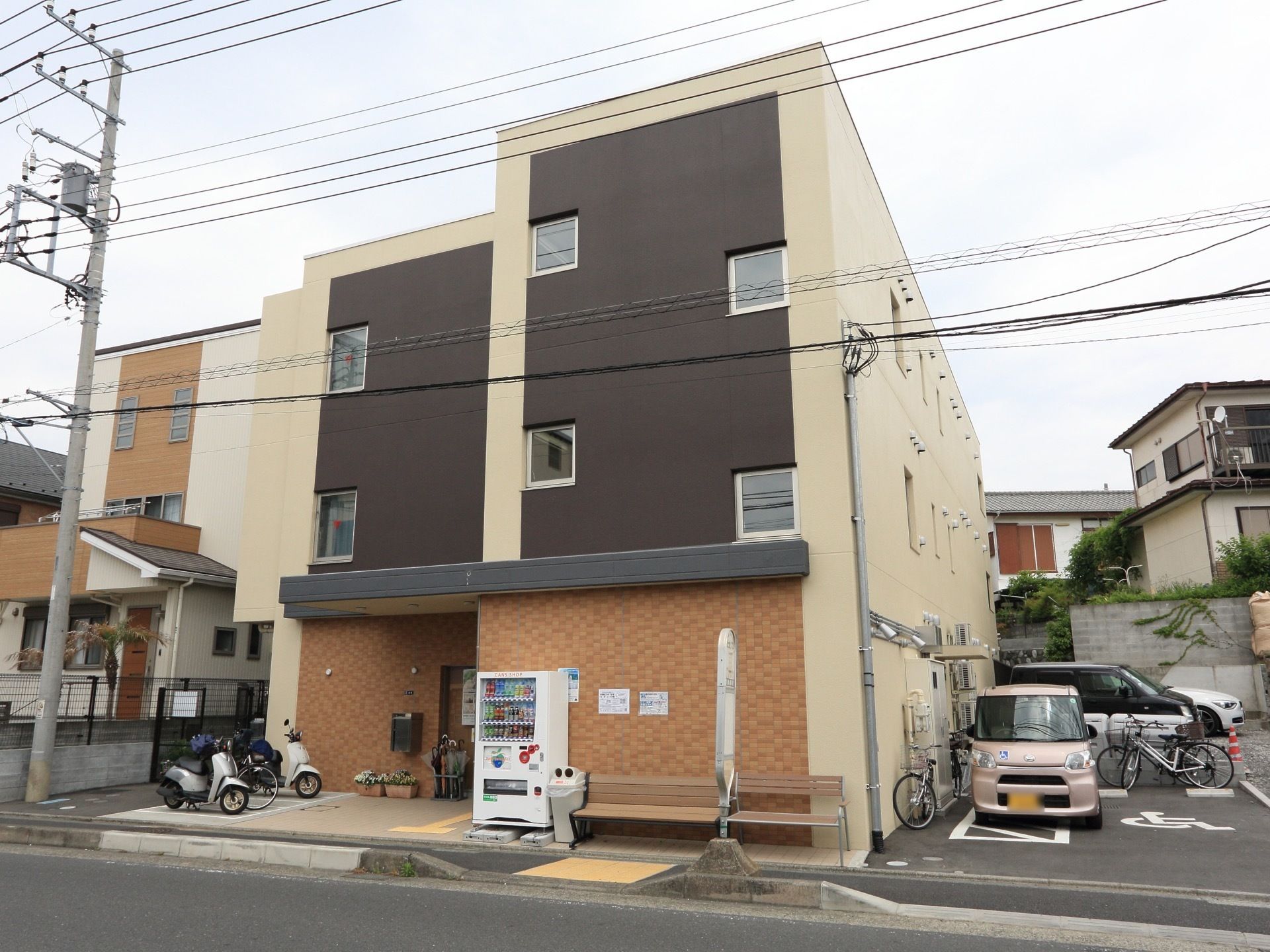 住宅街にただずむ建物は、一見するとマンションのように見える。落ち着いた色使いで周囲に溶け込んでいる。