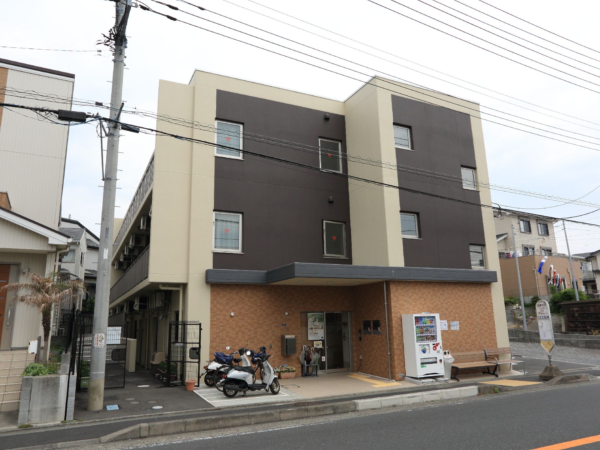 入り口前にバイクが二台停まっているグループホーム施設外観