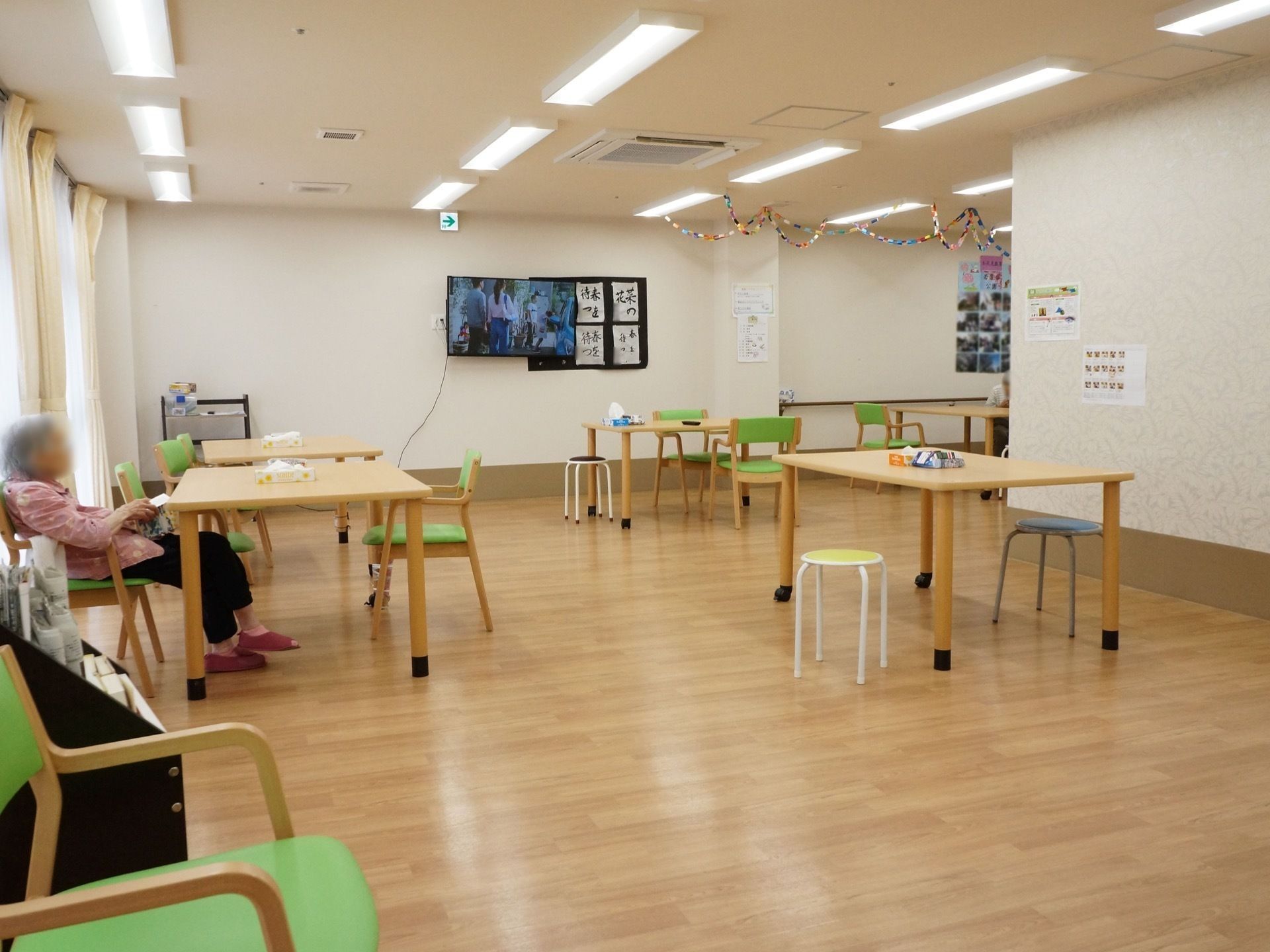 ダイニングテーブルと緑色の椅子が置かれている共有スペース