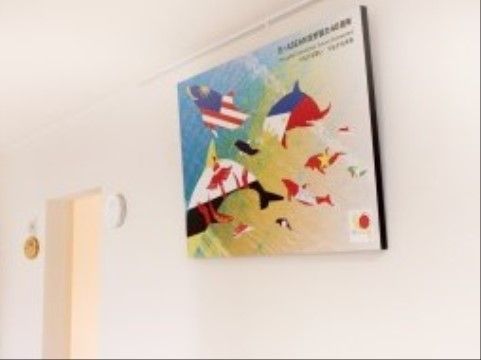 壁にかけられている、イルカの形にかたどられた国旗のイラスト