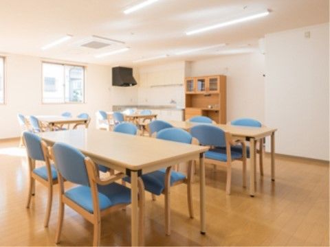 四つのダイニングテーブルと青い椅子が置かれているダイニングルーム