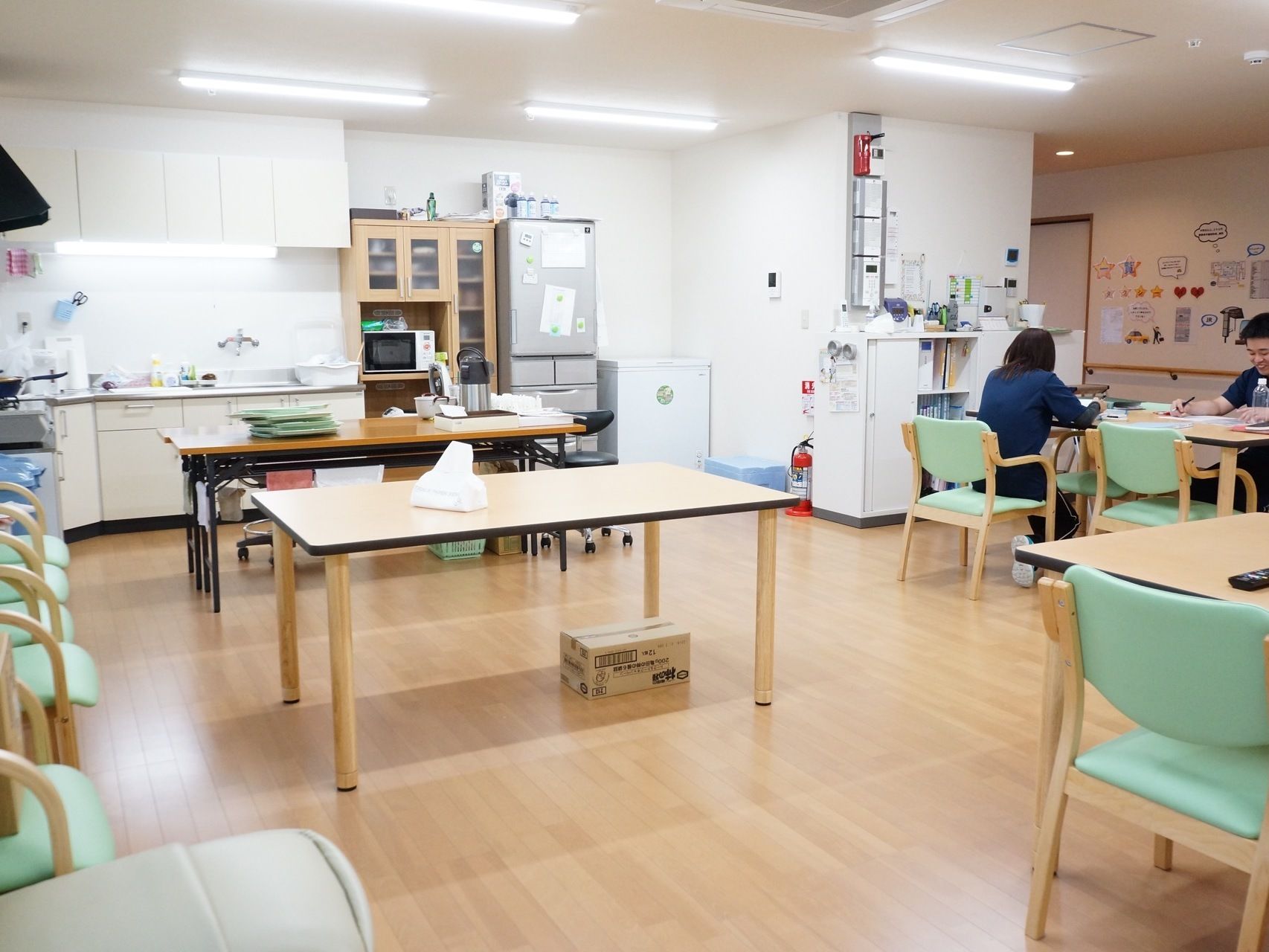 コーナーにキッチンが設置されているアットホームな雰囲気の共有スペースにはテーブルがゆったりとした間隔で置かれている。