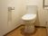 白いクロス張りの壁とフローリングの床が明るい雰囲気の広々としたトイレには、手すりや緊急の場合にも安心なナースコールが設置されている。