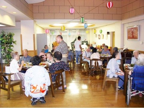ダイニングルームで食事を楽しんでいる、大勢の入居者