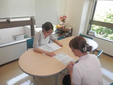 楕円形のテーブルに座っている、お団子ヘアの女性二人