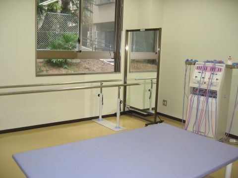 全身鏡とくすんだ青いテーブルが置かれている共有スペース