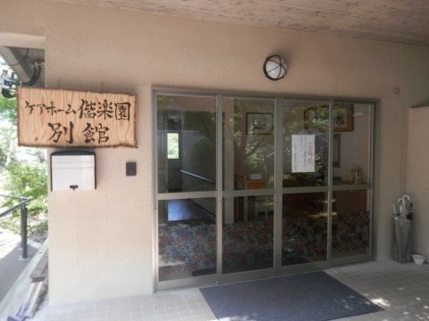 建物の玄関はガラス戸になっており、内部をうかがうことができる。ガラス戸の真上には照明があり、壁には施設の看板が取り付けられている。
