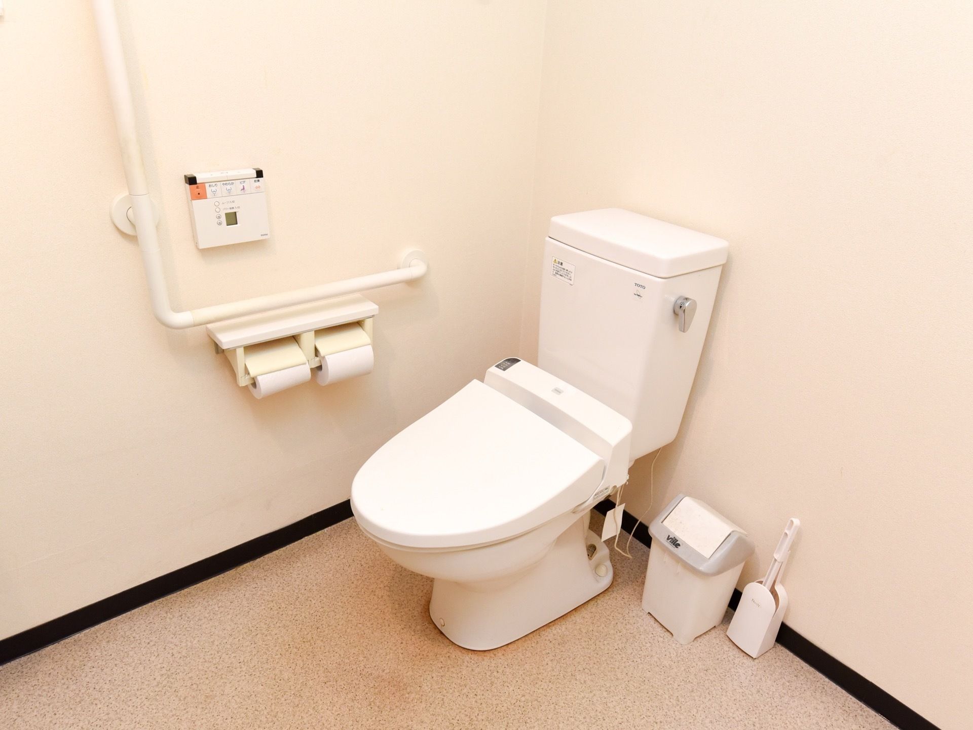 便座の横の壁にはL字型の手すりや操作ボタンなどが付いている。広々としており、車椅子ご利用の方でも楽に入れる。
