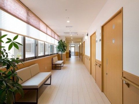 廊下の幅は十分に広く、片側の壁には手すりが設置され、引き戸が並んでいる。また片側にはガラス窓が設けられている。