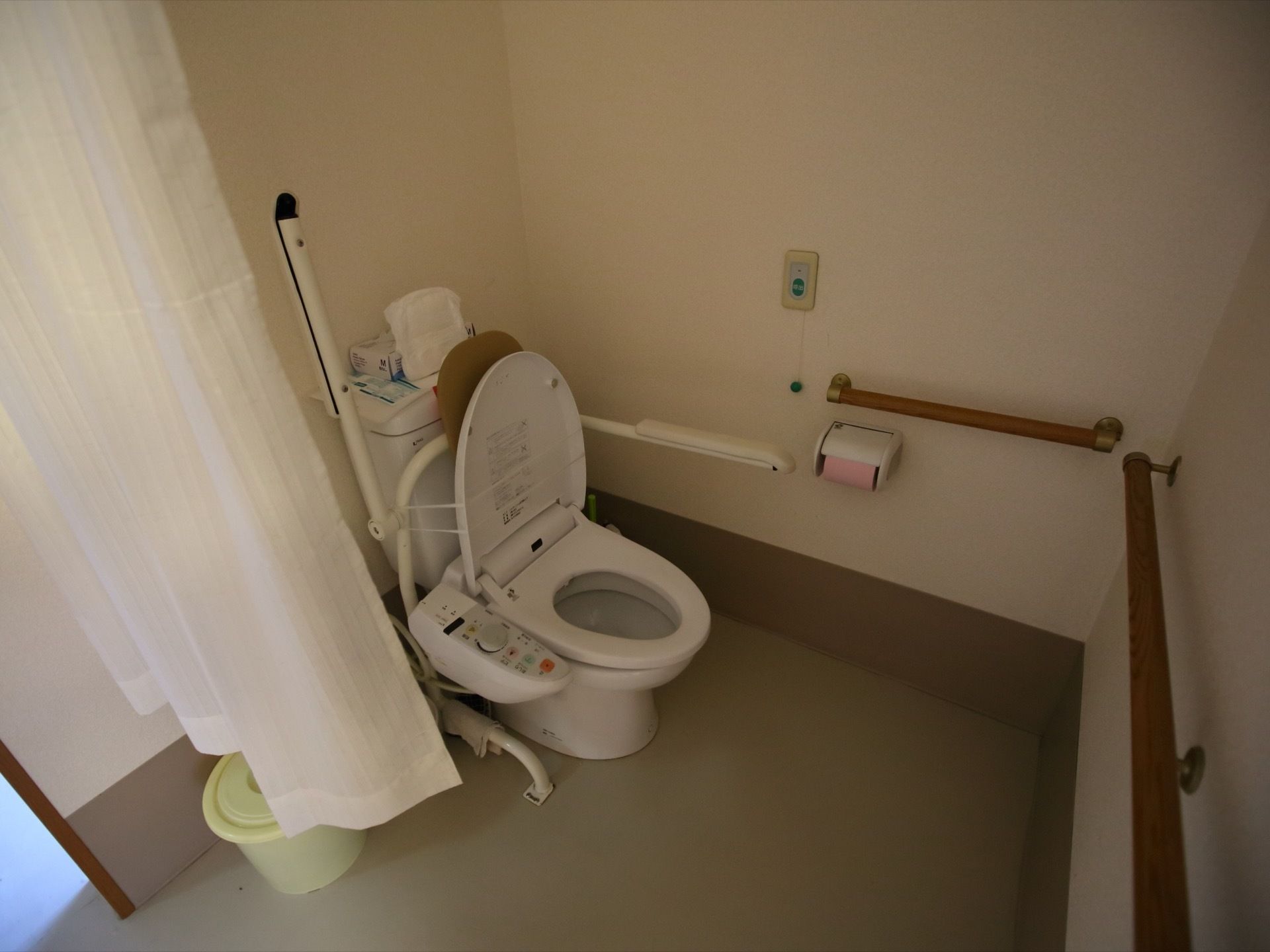 壁だけでなく便器の真横にも手すりがあり、体を安定させて使用できる。座ったままの状態で全てのものに手が届く配置である。