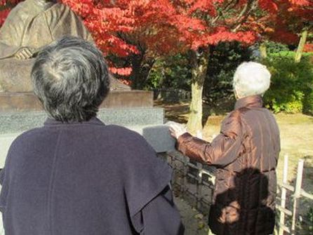 赤い紅葉と共に散策する人々