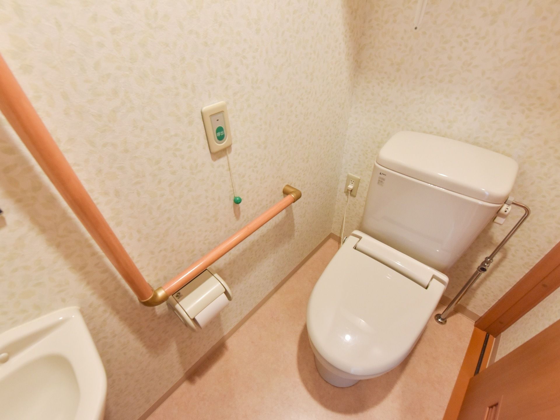洋式トイレがあり、トイレットペーパーホルダーの周辺には手すりが取り付けられている。他にもナースコールが設置されている。