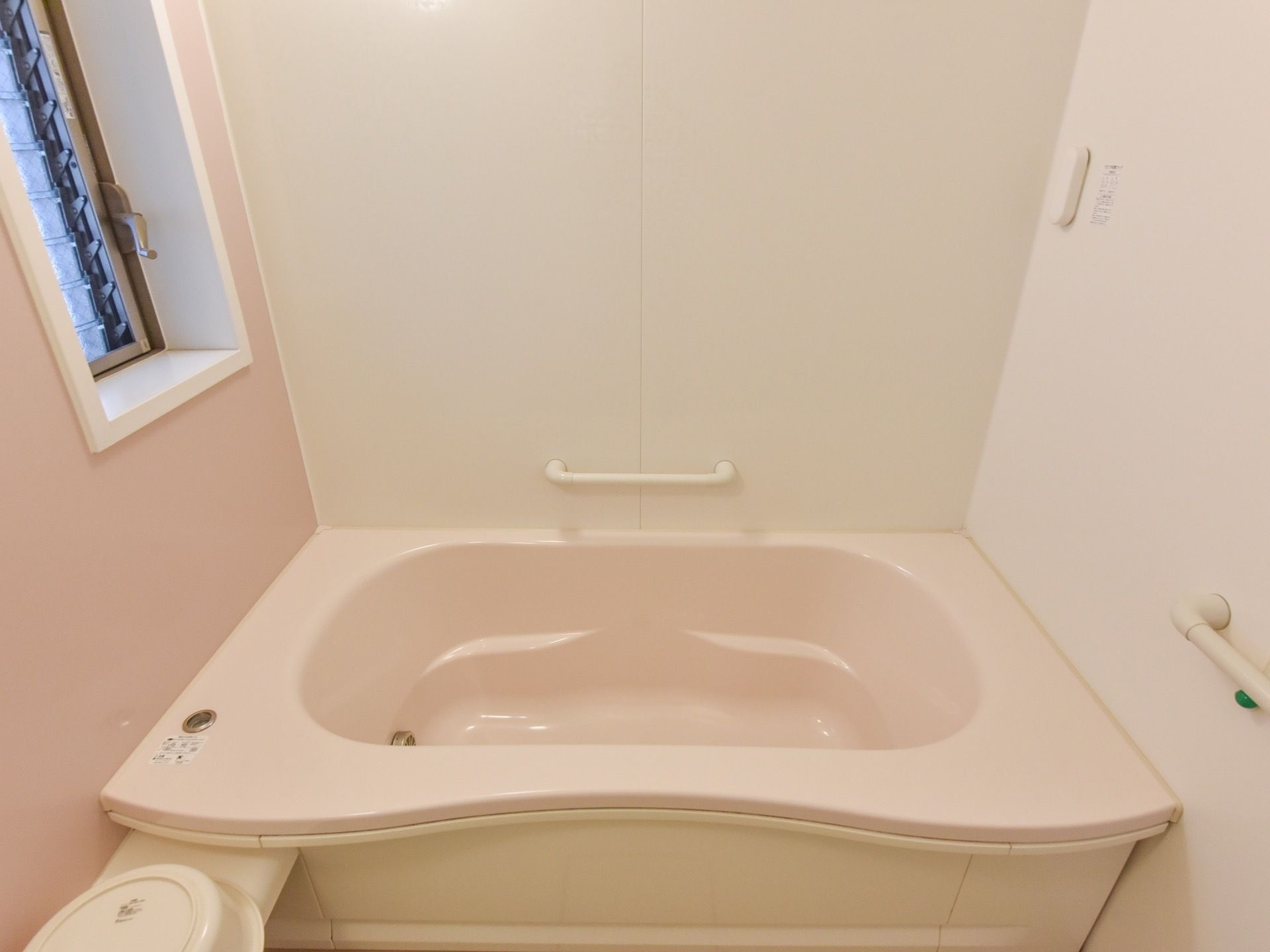 足を伸ばして入ることができる、大きな浴槽を備えた個浴室がある。壁には歩行をサポートする手すりが備え付けられている。