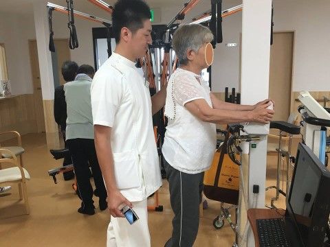 トレーニングルームでリハビリを受けている理学療法士