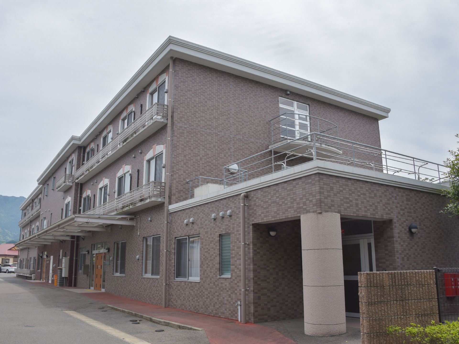 3階建でレンガ造りのモダンな雰囲気の洋館。エントランスには大きな屋根が付いているので、雨や雪の時も濡れる心配がない。