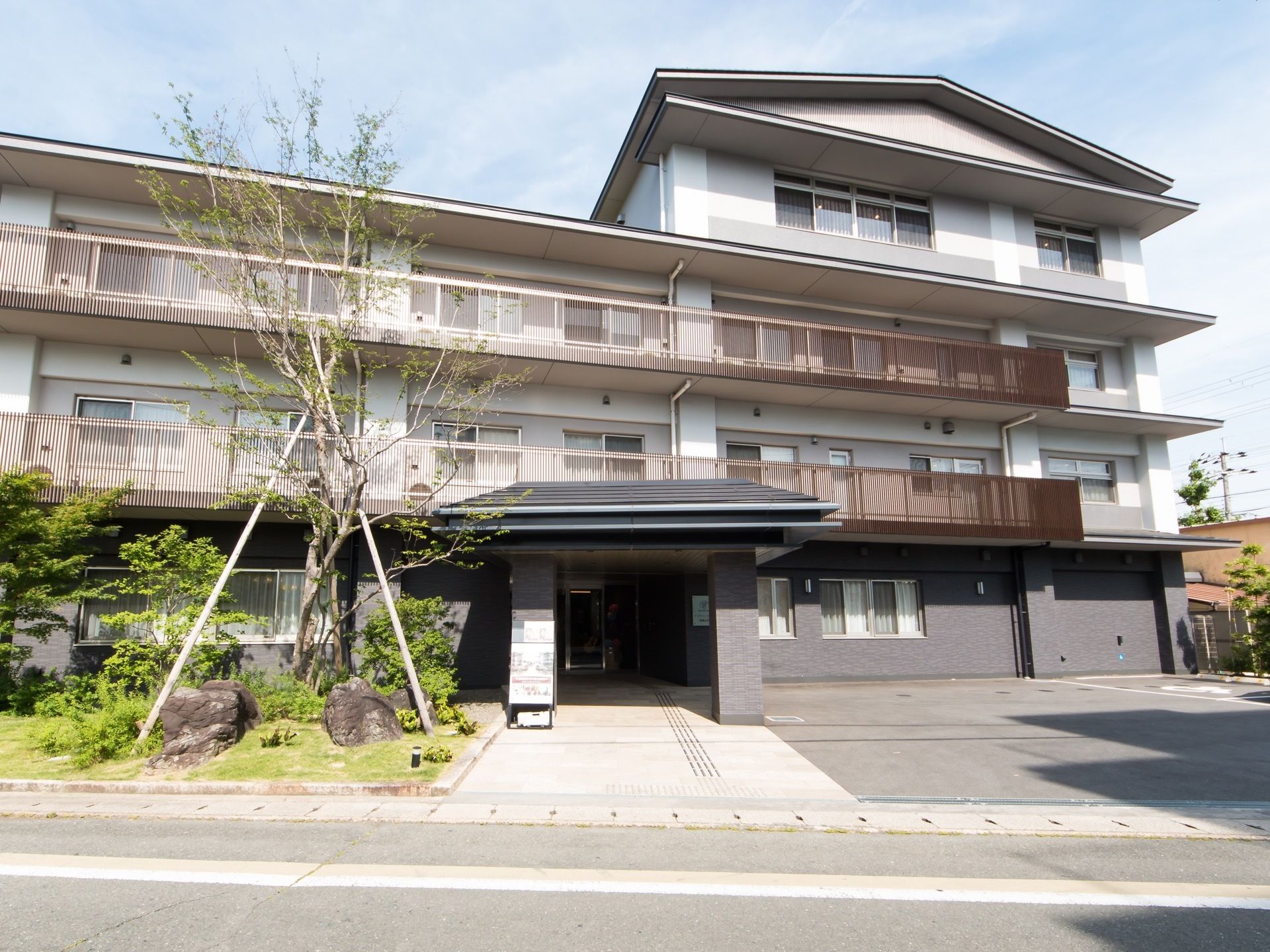 和風の佇まいが特徴の、一部４階建ての施設である。玄関横に大きな木が植えられており、支柱が立てられている。