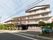 白色と薄い灰色を基調とした外壁で、一部４階建ての施設である。敷地内に車が停まっていて、その近くには消火栓が設置されている。
