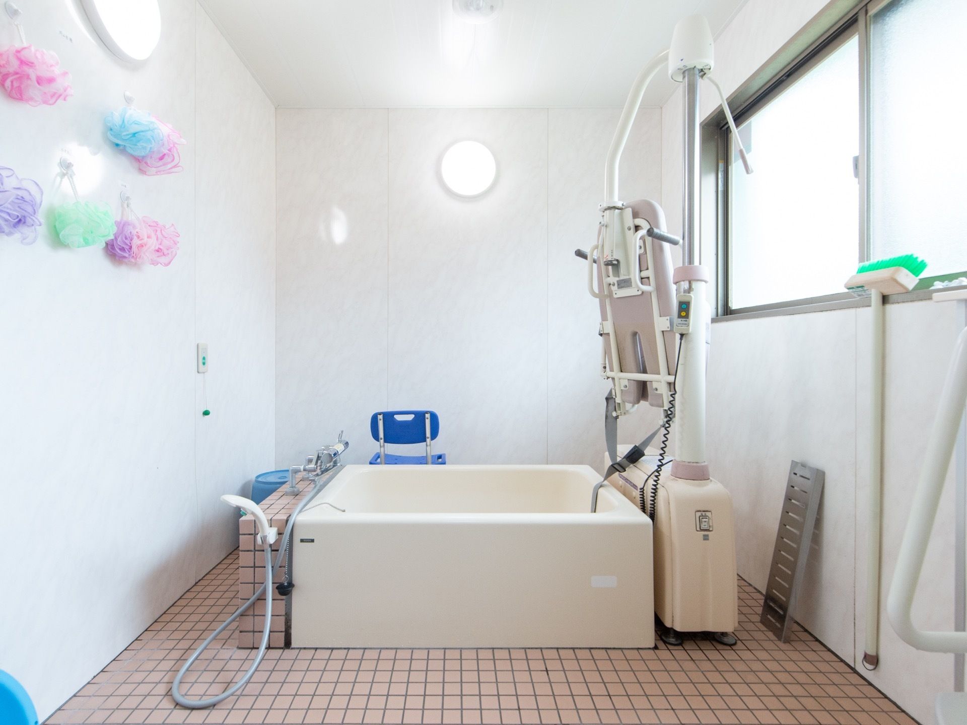 広々とした浴室の奥には浴槽が設置され、その傍らに電動リフトが配置されている。リフトを使用して安全に入浴できる。