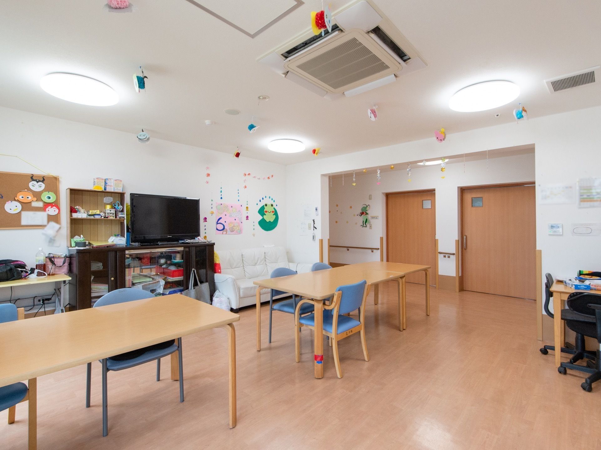 部屋の中央にテーブルが距離を空けて配置されている。通路が広く確保することとで、車椅子をご利用の方が安全に移動できるようにしている。