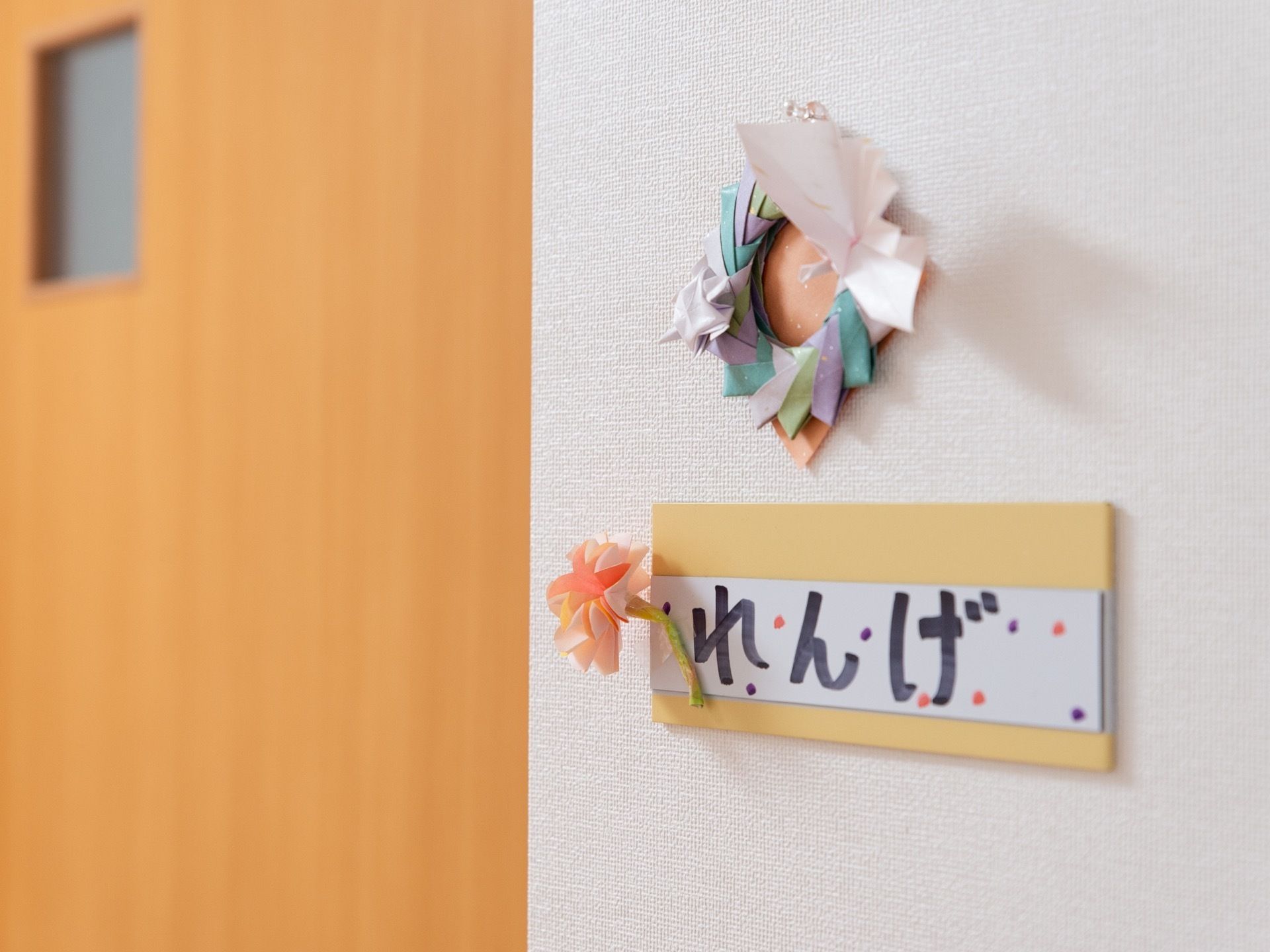 居室の外には、部屋の名前と花の装飾の付いたプレートが設置されている。入居者様が居室を判別しやすいように工夫されている。