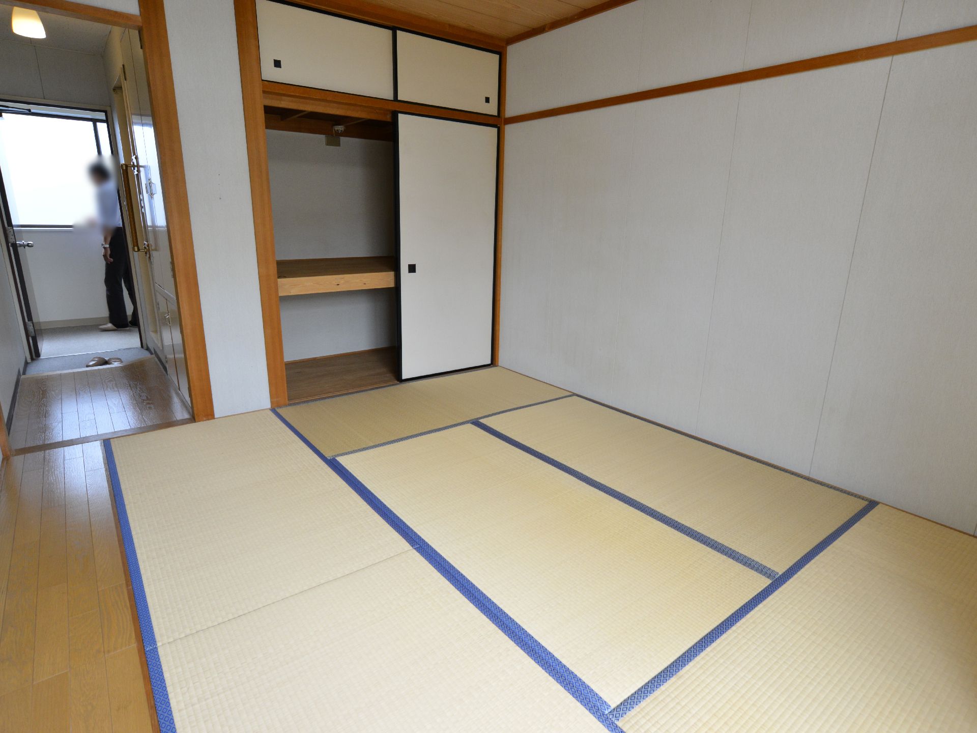 入口ドアが開けられ、押入れと床の間がある６畳の居室