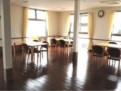 大きい窓がいくつかあるので明るい共有スペースとなっている。移動しやすいようにダイニングセットは間隔を開けて配置している。