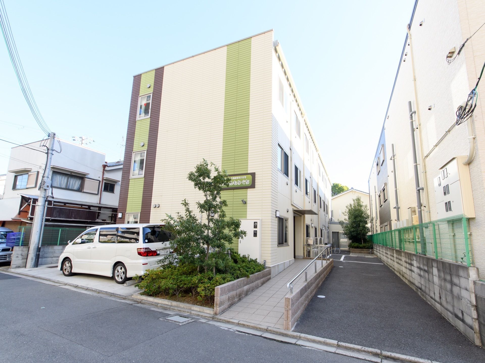 住宅街の中にしっくり溶け込んでいる３階建ての施設の様子。玄関が車道から少し奥まったところにあるので、安心である。