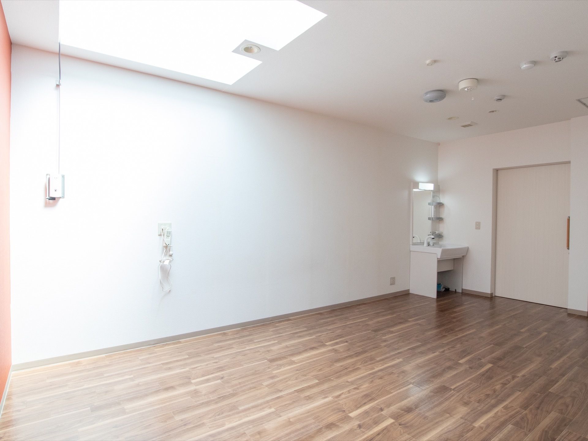 居室はほぼ四角の間取りで、入り口横に洗面台がある。天井は一部が吹き抜けになっている。壁に屋根を動かすスイッチがある。