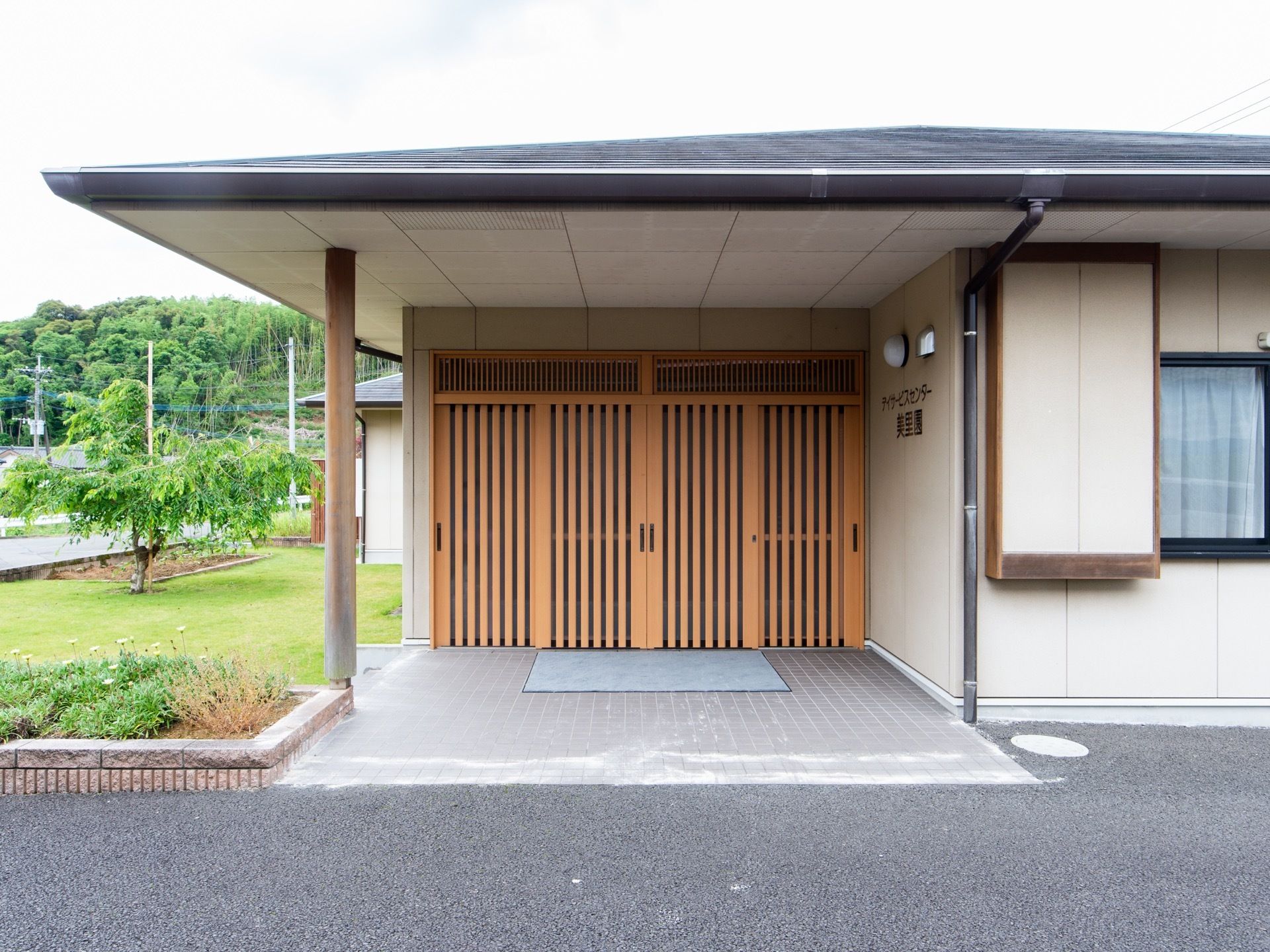 和風造りの落ち着きのあるエントランスである。周辺は広々としたアスファルトで整地され、バリアフリー構造である。