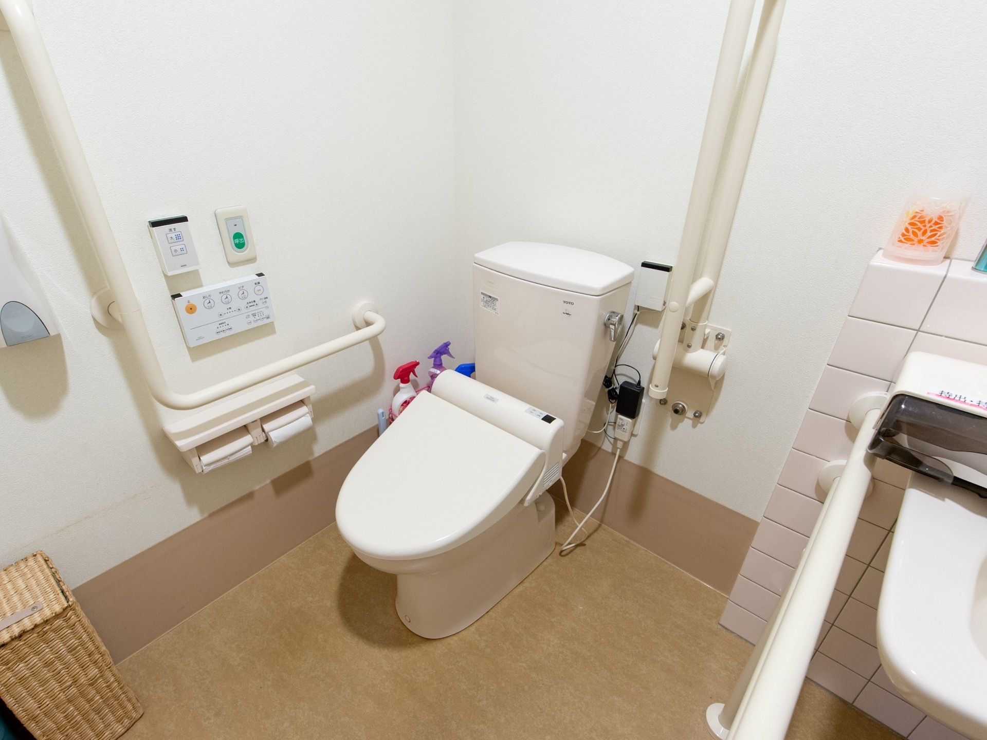 白を基調とした清潔感あふれるトイレである。温水洗浄便座や手すり、ナースコールが完備され、隣には洗面スペースがある。