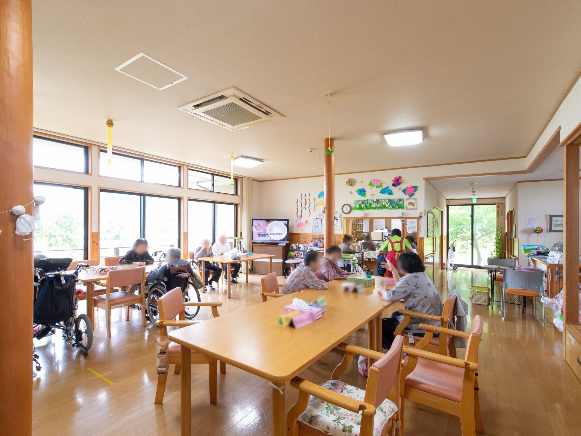 広々とした日射しが差し込む明るい食堂である。４人掛けのダイニングテーブルや大型液晶テレビ、エアコンが完備されている。