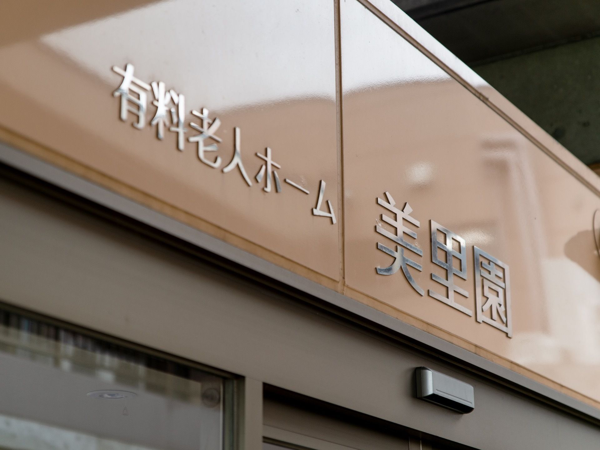 エントランスのドアの上に施設名が表示されている。ブラウンを背景にシルバーの文字なので、遠くから見てもわかりやすい。