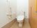 白を基調とした明るく清潔感のあるトイレである。非常呼び出しブザーや手すり、温水洗浄便座が完備されている。