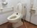 トイレには暖房便座のついた洋式便器を設置している。また足の不自由な高齢者のために、壁には可動式の手すりが取り付けられている。