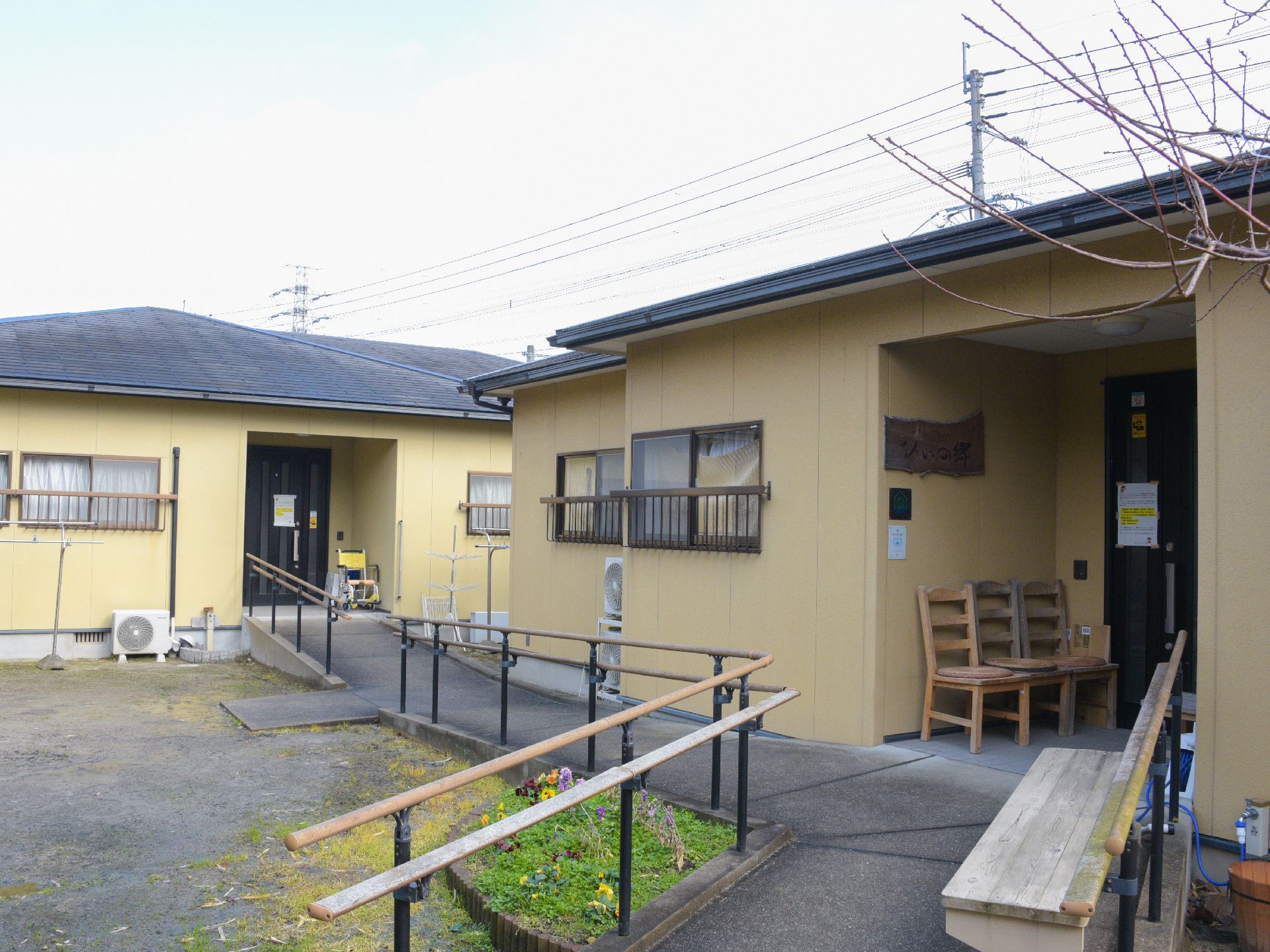 ２棟並んだベージュ色の建物の間を渡る手すり付きのスロープ