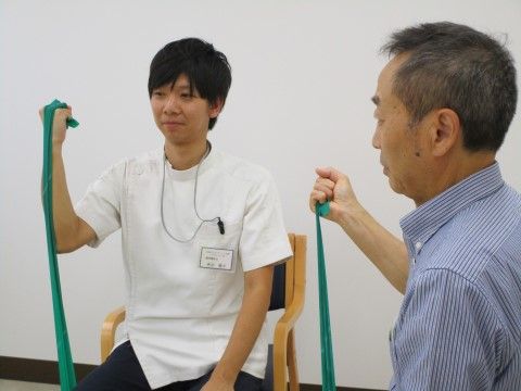 緑の布を持って、スタッフの動作をまねている男性入居者様