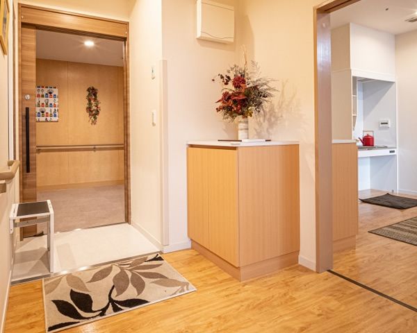 玄関と部屋の段差が無い。下駄箱が壁側に設置されている。鏡や物を置いたり腰を掛けたり出来るスペースがある。